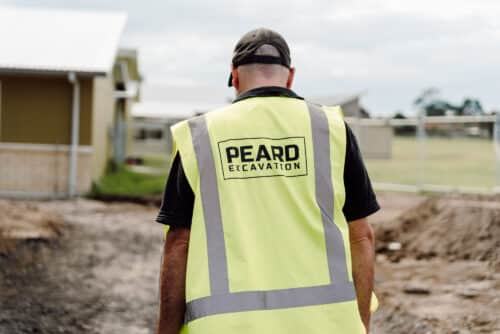 Toby Peard, Managing Director of Peard Excavation, on site with excavator in the Bay of Plenty